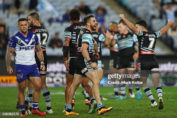 Craig Garvey of the Bulldogs looks dejected as Jack Bird of the Sharks celebrates victory during the round 13 NRL match between the Canterbury...