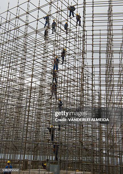 Workers set up the structure for the Arena Olimpica beach court in Copacaban beach where the Beach volleyball tournament will be held in the upcoming...