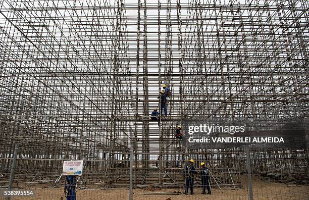 Workers set up the structure for the Arena Olimpica beach court in Copacaban beach where the Beach volleyball tournament will be held in the upcoming...