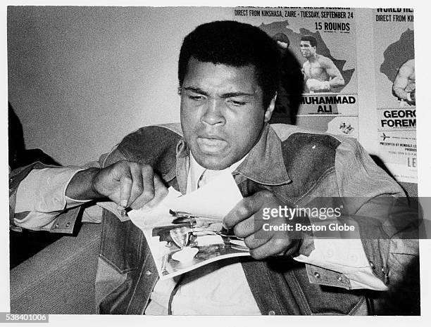 Muhammad Ali tears up a photo of George Foreman at Logan International Airport in Boston in an undated photo.