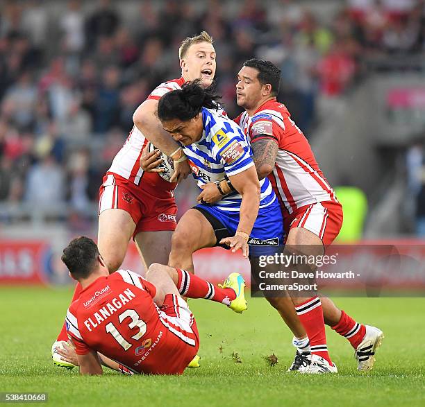 Wigan Warriors' Taulima Tautai is tackled by Salford Red Devils' Mark Flanagan, Craig Kopczak and Ben Murdoch-Masila during the First Utility Super...