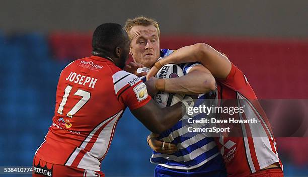 Wigan Warriors' Dom Crosby is tackled by Salford Red Devils' Phil Joseph and Adam Walne during the First Utility Super League Round 17 match between...