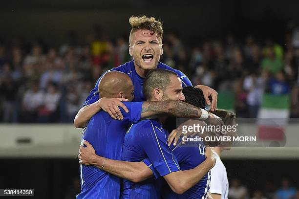 Italy's midfieldrer Antonio Candreva celebrates with teammates Italy's forward Ciro immobile and Leonardo Bonucci after scoring a penalty kick during...