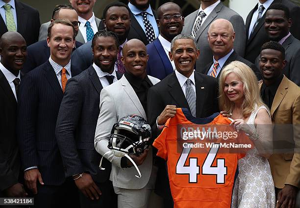 President Barack Obama holds up a Denver Broncos jersey presented to him as a gift by Annabel Bowlen , wife of Broncos majority owner Pat Bowlen,...