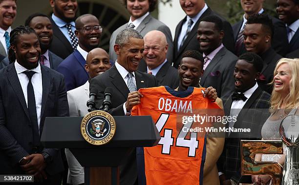 President Barack Obama holds up a Denver Broncos jersey presented to him as a gift by Annabel Bowlen , wife of Broncos majority owner Pat Bowlen,...