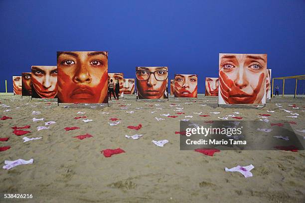 Photographs by Marcio Freitas of models portraying women who are abused are displayed on Copacabana beach with 420 pairs of underwear at a...