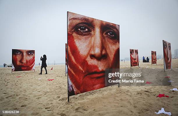 Photographs by Marcio Freitas of models portraying women who are abused are displayed on Copacabana beach with 420 pairs of underwear at a...