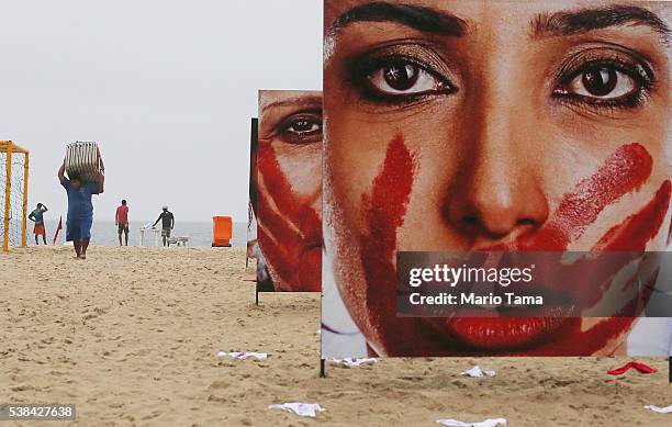 Photographs by Marcio Freitas of models portraying women who are abused are displayed on Copacabana beach with 420 pairs of underwear at a...