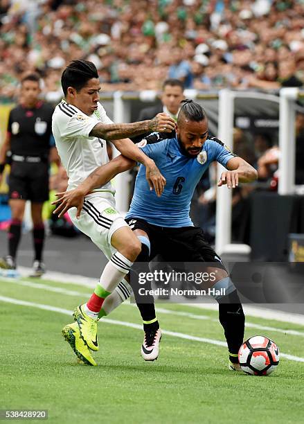 Alvaro Pereira of Uruguay battles for the ball with Javier Aquino of Mexico during the first half of a group C match at University of Phoenix Stadium...