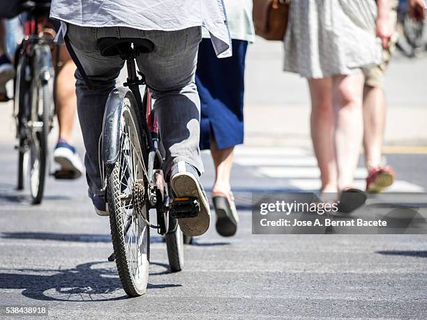 persons crossing a street in the city walking and in bicycle - walk dont walk signal stock pictures, royalty-free photos & images