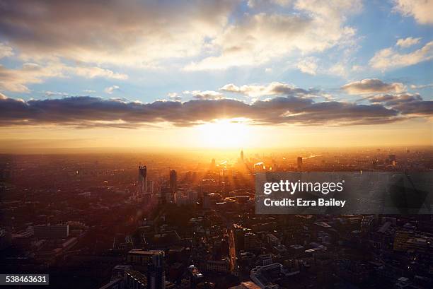 the sun rises through the city on a misty morning. - sunrise imagens e fotografias de stock