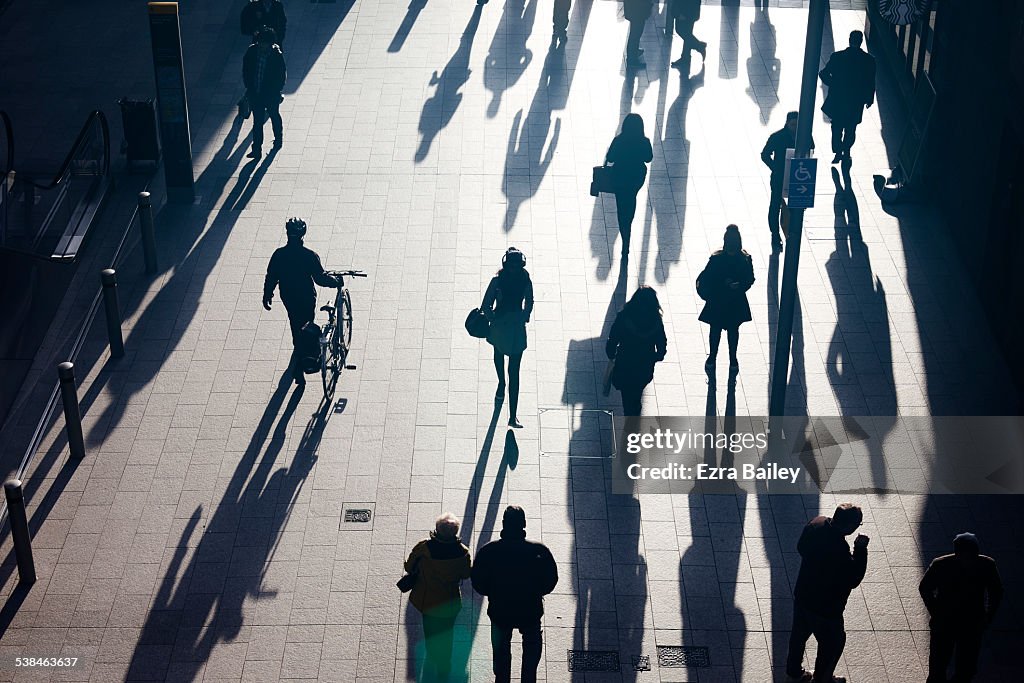 Silhouettes of people walking in the sun.