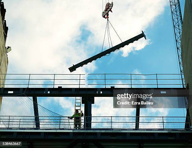 construction worker positioning a piece of steel. - steel railings stock pictures, royalty-free photos & images