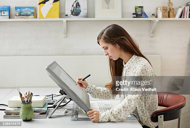 young graphic designer working with pen on screen - designer photos et images de collection