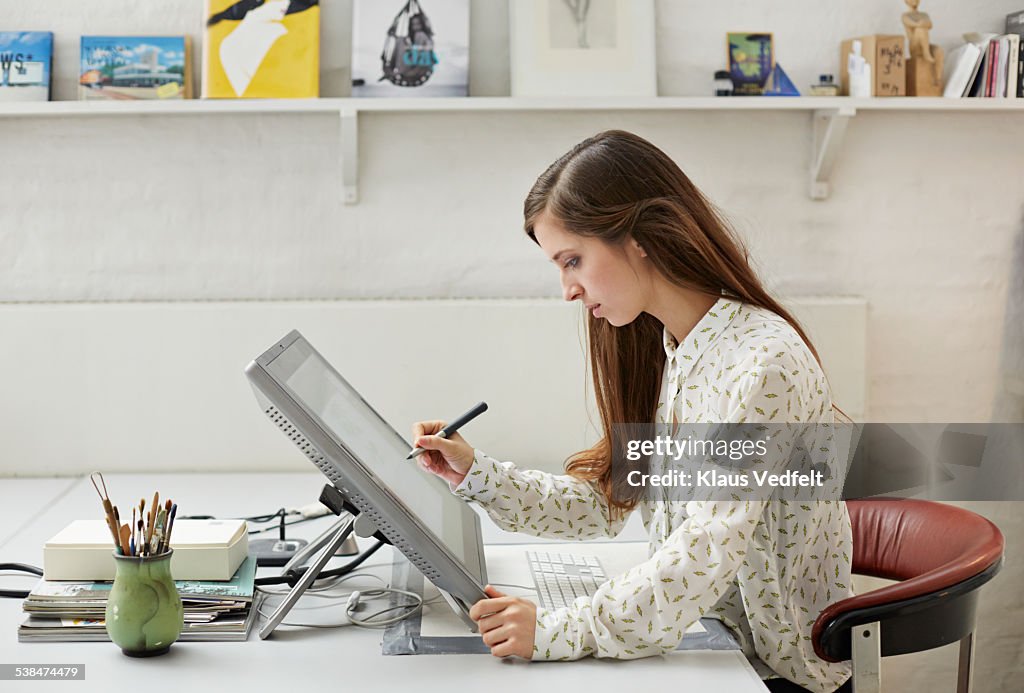 Young graphic designer working with pen on screen