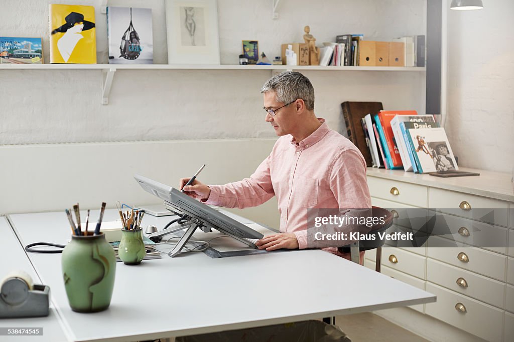 Man with glasses working w. digital pen on screen