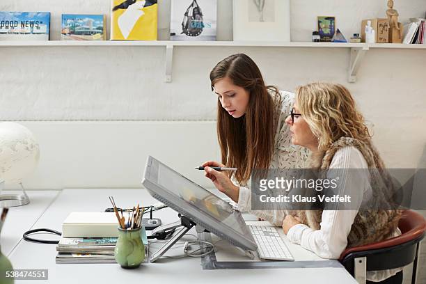 mature woman showing intern graphics on screen - designer photos et images de collection