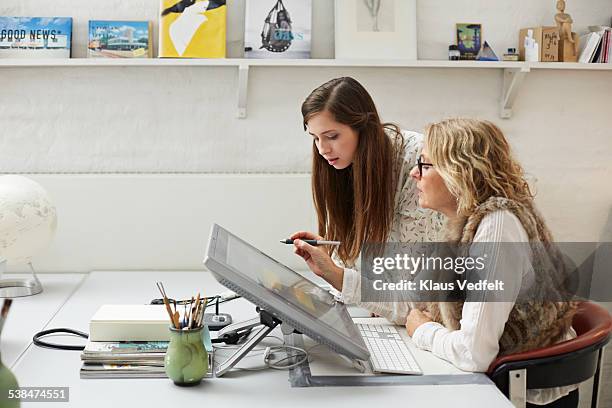 mature woman showing intern graphics on screen - ontwerper stockfoto's en -beelden