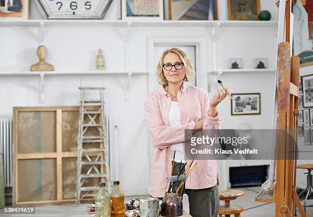 portrait of mature woman at her home studio - artist portrait stock pictures, royalty-free photos & images