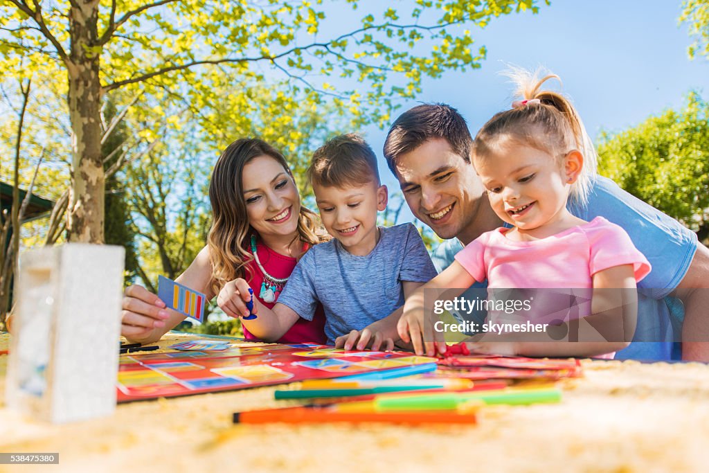 Happy family spending a day outdoors and playing board game.