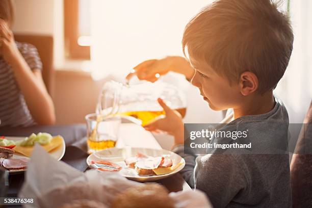 kids eating breakfast on sunny morning - apple juice stock pictures, royalty-free photos & images