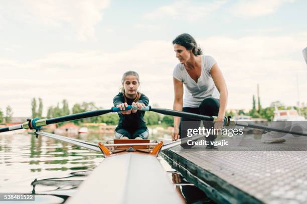 single scull rowing instructions from coach. - wrikken roeisport stockfoto's en -beelden