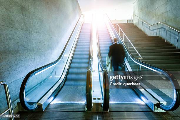 escalator with businessman - escalators stockfoto's en -beelden