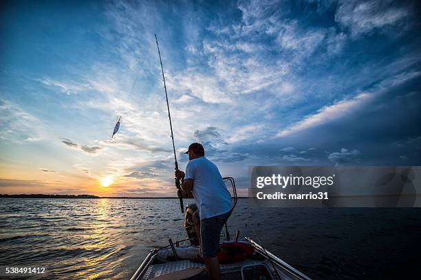 pôr do sol sobre o lago - pescador imagens e fotografias de stock