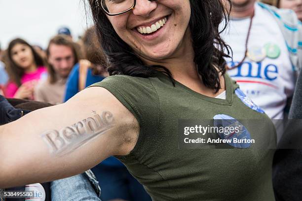 An audience member flexes her muscles at a rally held by Democratic presidential candidate Senator Bernie Sanders at the Presidio while waiting for...