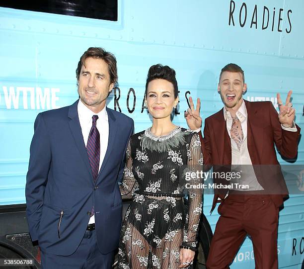 Luke Wilson and Carla Gugino pose while Richard Colson Baker aka Machine Gun Kelly photobombs in the background at the Los Angeles premiere of...