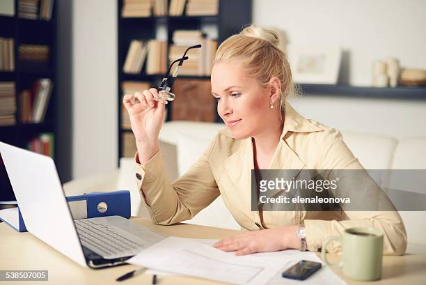blonde woman working at home - steuerberater stock-fotos und bilder