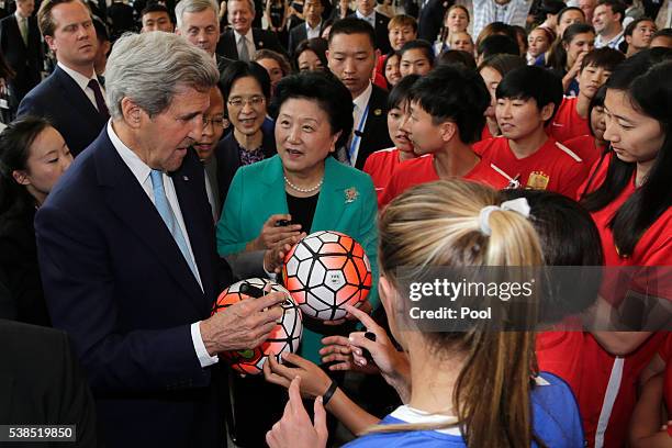 Secretary of State John Kerry and Chinese Vice Premier Liu Yandong signs autographs for the female soccer players from the U.S. And China as they...