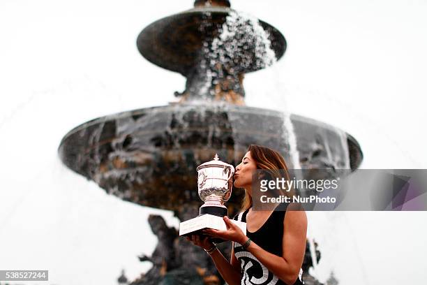 Garbine Muguruza of Spain celebrates victory and poses for the photographers with the trophy a front the fontaine at the concorde near Champs Elysees...