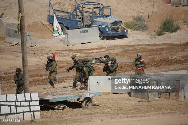 Israeli soldiers evacuate a mock injured soldier during a joint army drill which includes infantry, aviation, tanks and artillery units in the army...