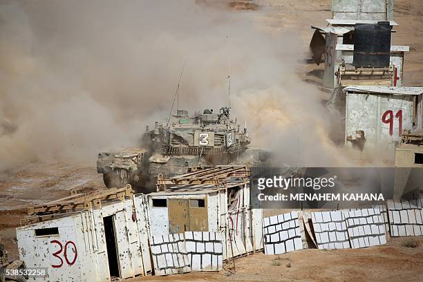 An Israeli tank fires during a joint army drill which includes infantry, aviation, tanks and artillery units in the army training base of Shizafon in...