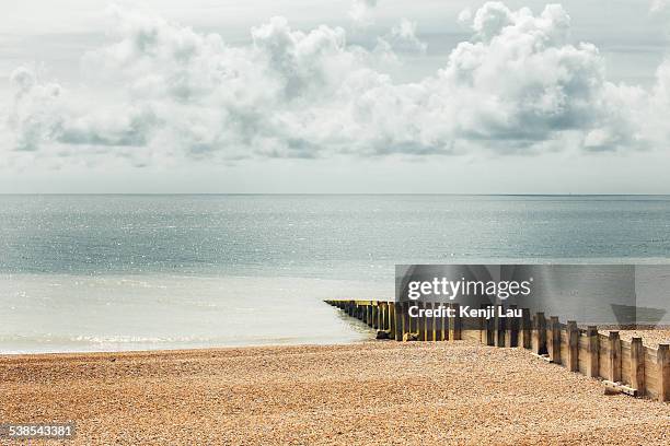 fence jutting out into the sea - beach fence stock-fotos und bilder