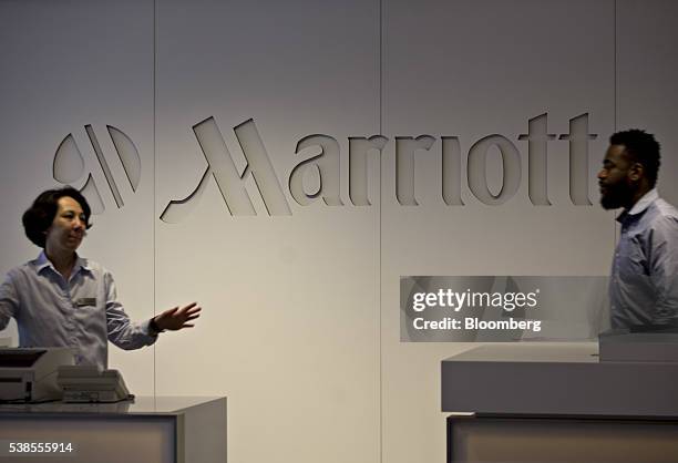 Employees stand next to Marriott International Inc. Signage displayed in the company's headquarters lobby in Bethesda, Maryland, U.S., on Wednesday,...