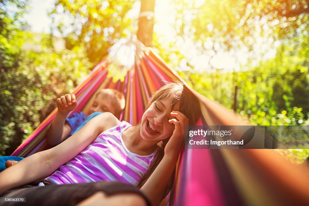 Kinder Spaß haben auf Hängematte auf Sommertag