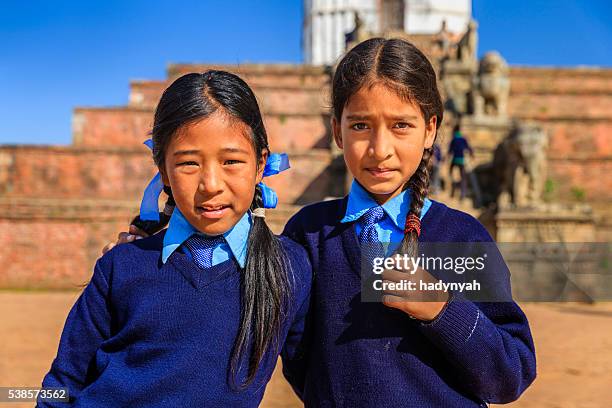 two ittle schoolgirls on durbar square in bhaktapur, nepal - nepal culture stock pictures, royalty-free photos & images