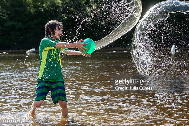 young boy tossing water from bucket at musante beach. - wade bildbanksfoton och bilder