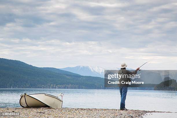 a man fishing on whitefish lake in whitefish, montana. - lake whitefish stock-fotos und bilder