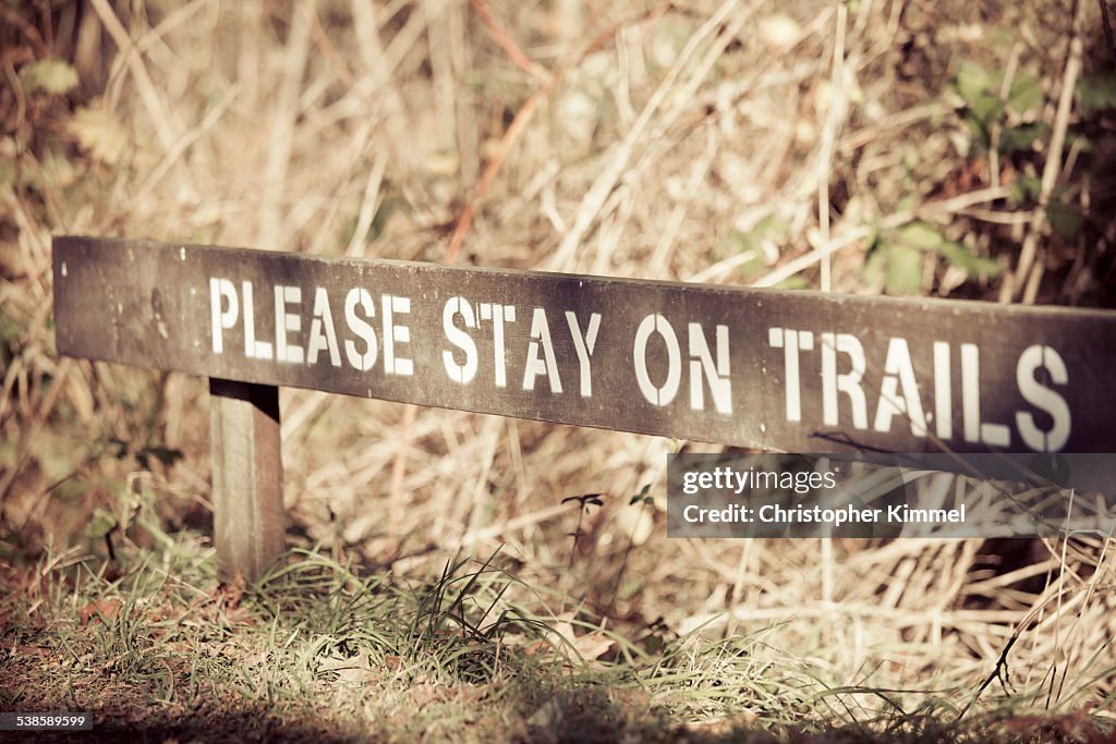 Please stay on trails sign.