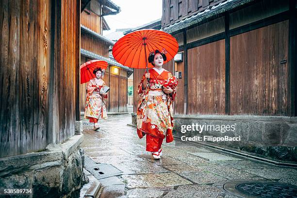 maiko women walking in kyoto - kioto prefectuur stockfoto's en -beelden