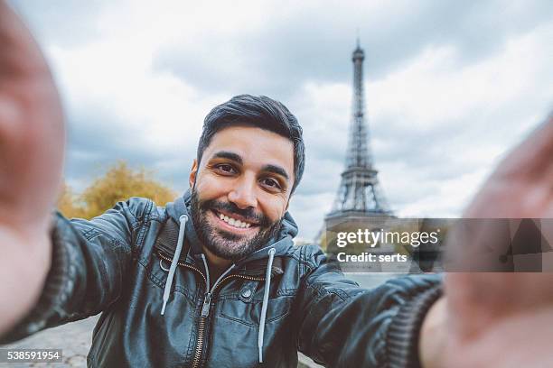 young man taking selfie with smartphone - person eiffel tower stock pictures, royalty-free photos & images