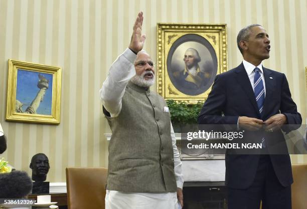 India's Prime Minister Narendra Modi waves as US President Barack Obama looks on following a meeting in the Oval Office of the White House on June 7,...