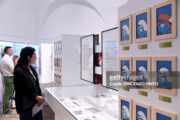 Woman looks at cartoons boards of the Smurfs created by the Belgian cartoonist Pierre Culliford, who worked under the pseudonym of Peyo, during the...