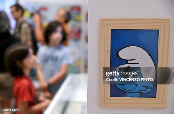 People look at cartoons boards of the Smurfs created by the Belgian cartoonist Pierre Culliford, who worked under the pseudonym of Peyo, during the...