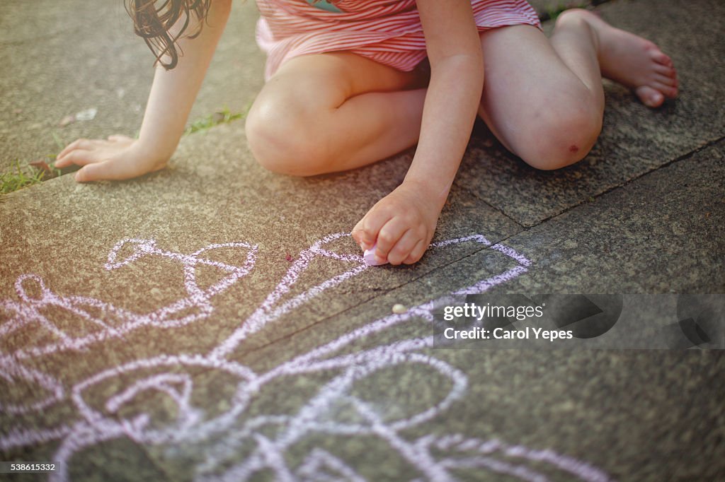 Girl drawing  with sidewalk chalk