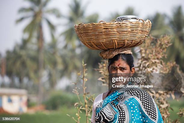 south indian farmer balancing a basket on her head. - south indian food stock pictures, royalty-free photos & images