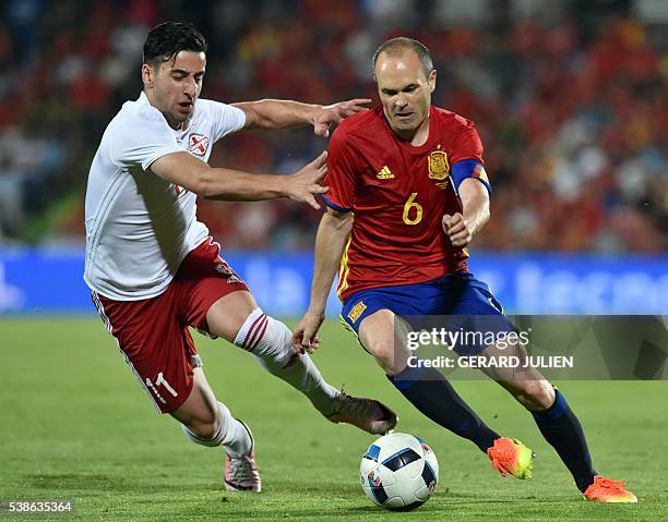 Georgia's forward Giorgi Chanturia vies for the ball with Spain's midfielder Andres Iniesta during the EURO 2016 friendly football match Spain vs...